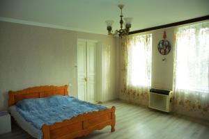 een slaapkamer met een bed, 2 ramen en een kroonluchter bij Guesthouse Lasha in Khoni