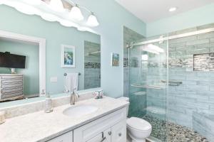 a bathroom with a sink and a glass shower at Blu Star Oasis Beach Htd Pool Pets Firepit in Saint Augustine