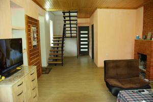 een kamer met een woonkamer met een tv en een trap bij Guesthouse Lasha in Khoni
