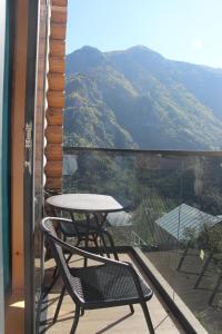 een tafel en stoelen op een balkon met uitzicht op de bergen bij Hotel ANNA PALACE in Khulo