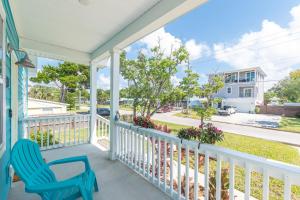 a porch with a blue chair and a view of the street at Blu Star Oasis Beach Htd Pool Pets Firepit in Saint Augustine