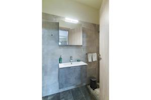 uma casa de banho com um lavatório e um espelho em Appartement pour deux personnes em Patitiri