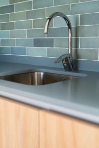 a stainless steel sink in a kitchen with blue tiles at Nazaret Beach - Adults only in Arrecife