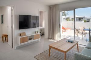 ein Wohnzimmer mit einem TV an der Wand in der Unterkunft Nazaret Beach - Adults only in Arrecife