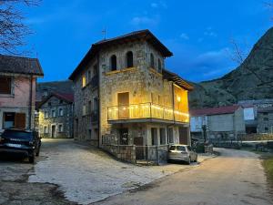 un antiguo edificio de piedra con balcón en una calle en Moradas Portilla, en Portilla de la Reina