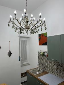 een keuken met een kroonluchter boven een wastafel bij Le muratelle guest house in Salerno