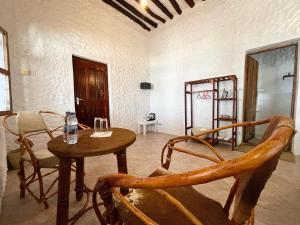 um quarto com uma mesa e cadeiras num quarto em HA Beach Hotel Zanzibar em Jambiani