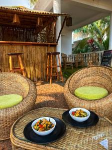 twee kommen eten op een tafel met rieten stoelen bij SOLS Backyard in Arambol