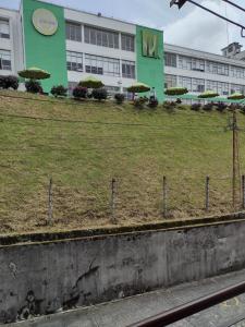 un bâtiment avec une pelouse et des parasols devant lui dans l'établissement Casa frente Universidad de Manizales 4 habitaciones cerca al centro de la ciudad, à Manizales