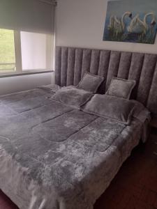a large bed in a bedroom with a large headboard at Casa de 3 habitaciones y 3 baños cerca al centro de la ciudad in Manizales
