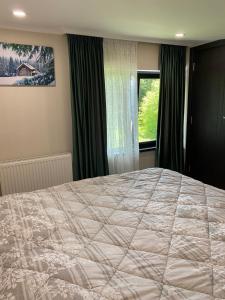 a bedroom with a large bed and a window at Duplex apartment near the forest in Bakuriani