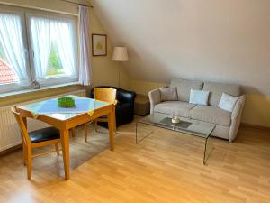 a living room with a couch and a table at Haus Delphin - Ferienwohnung 1 in Norderney