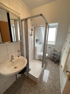 a bathroom with a shower and a sink at Haus Delphin - Ferienwohnung 1 in Norderney