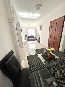 una sala de estar con una mesa con un bol de fruta. en Apartamento Vacacional Cartagena Colombia, en Cartagena de Indias