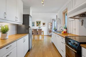 a kitchen with white cabinets and a wooden floor at Large home in Sola in Tananger