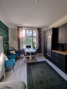 a living room with a table and a kitchen at Boutique Studio in the city in Helsinki