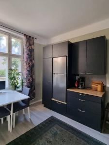 a kitchen with black cabinets and a table and a table and a dining room at Boutique Studio in the city in Helsinki +2 photos