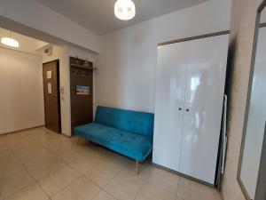 um quarto com um sofá azul e um armário em BlueSea Summerland Apartments em Mamaia