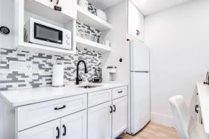 eine weiße Küche mit Spüle und Mikrowelle in der Unterkunft Matchless Luxury III on Mill Pond in Wesley Chapel + 42 Fotos