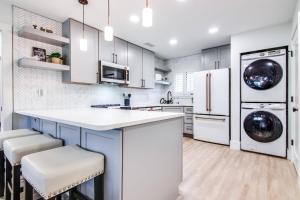 a kitchen with white cabinets and a washer and dryer at Matchless Luxury III on Mill Pond - 3168-3170 in Wesley Chapel