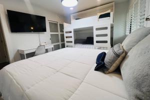 ein Schlafzimmer mit einem großen weißen Bett und einem Fernseher in der Unterkunft Matchless Luxury III on Mill Pond in Wesley Chapel