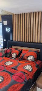 1 cama con edredón y almohadas de color negro y rojo en Casa Transylvania en Lupşa