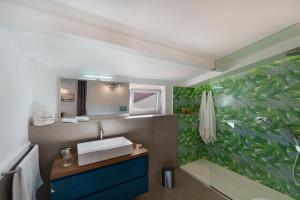 een badkamer met een wastafel en een groene groene groene groene muur bij Enfasi Holiday Home in Vico Equense