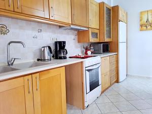 a kitchen with wooden cabinets and a stove top oven at Bright apartment in Nea Palatia • Oropos in Néa Palátia