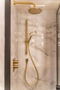 La salle de bains est pourvue d'une douche avec un pommeau de douche doré. dans l'établissement The Royal Albion, à Broadstairs