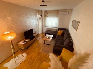 a living room with a couch and a tv at Apartman Royal 4 in Doboj