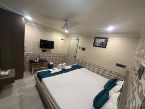 a bedroom with a bed and a television in it at Hotel Vinayak in Kharagpur