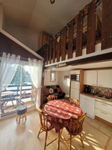 雷魯斯的住宿－Le Chalet, Superbe Duplex 3 étoiles proche du centre des Rousses, 5 personnes, Draps inclus，带桌子的厨房和带阳台的厨房