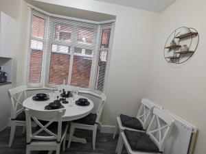 una mesa y sillas blancas en una habitación con ventana en Beacon House en Leicester