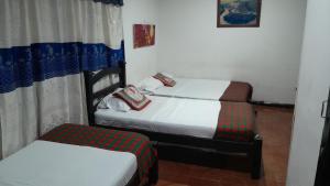 duas camas num pequeno quarto com três dos principais problemas em HOTEL NEIVA REAL em Neiva