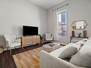 Downtown Condo في كليفلاند: غرفة معيشة مع أريكة وتلفزيون بشاشة مسطحة