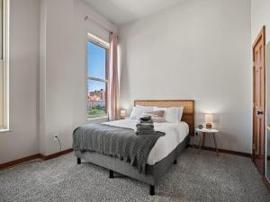 a bedroom with a bed and a large window at Downtown Condo in Cleveland