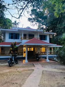 a house with a motorcycle parked in front of it at The Barefoot Varkala in Varkala