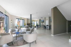 a lobby with chairs and tables in a building at Elcaro Luxury Villas-Urban Taupe in Midrand