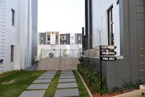 a street sign in front of a building at Elcaro Luxury Villas-Urban Taupe in Midrand
