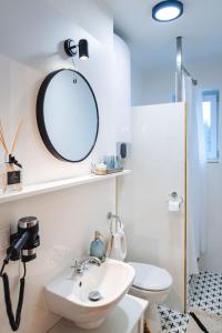 a bathroom with a sink and a mirror and a toilet at Silvie Apartments - Lazecká in Olomouc