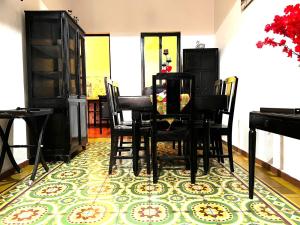 a dining room with a table and chairs on a rug at Titos Centric Home in Morelia +26 photos