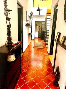 a hallway with a red and orange tile floor at Titos Centric Home in Morelia