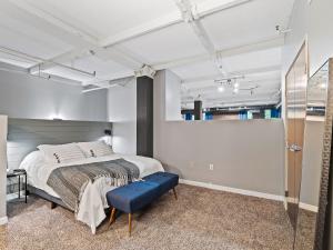 a bedroom with a large bed and a blue bench at Lakefront Loft - Downtown - Shuffle Board Table in Cleveland