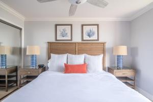um quarto com uma cama branca e uma almofada vermelha em F-2 Seascape Nirvana em Oceanside