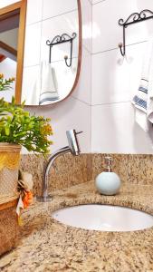 un bancone del bagno con lavandino e specchio di Aconchego próximo ao Thermas a Olímpia