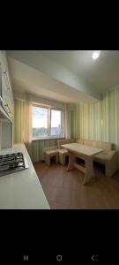 a kitchen with a table and a couch and a window at CreangaView in Chişinău