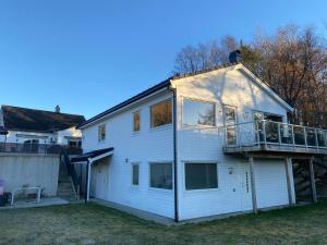uma casa branca com uma varanda em cima em Your Dream Studio in Bergen em Bergen