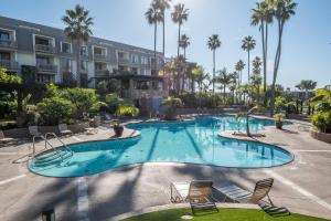 a large swimming pool with chairs and palm trees at G-314 Surf View Penthouse in Oceanside