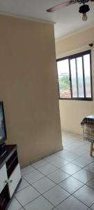 Il comprend un salon doté d'une télévision et d'une fenêtre. dans l'établissement Kit Nana, à Praia Grande