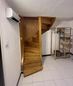 eine Holztreppe in einem Zimmer mit einer Wand in der Unterkunft Bienvenue chez Coco in Dunkerque